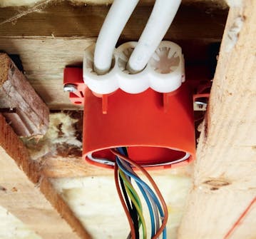 Opsætning af gipsloft: Elektrikeren trækker kabler og sætter loftsdåserne op Opsætning af gipsloft: Elektrikeren trækker kabler og sætter loftsdåserne op